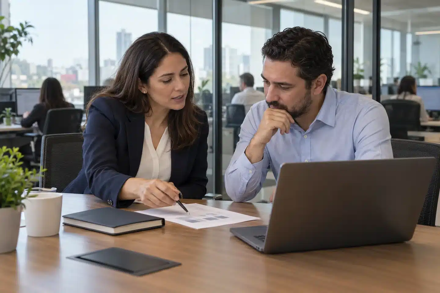 Outsourcing TI y colaboración con la empresa Profesional de TI y responsable de una empresa revisando documentación junto a una laptop